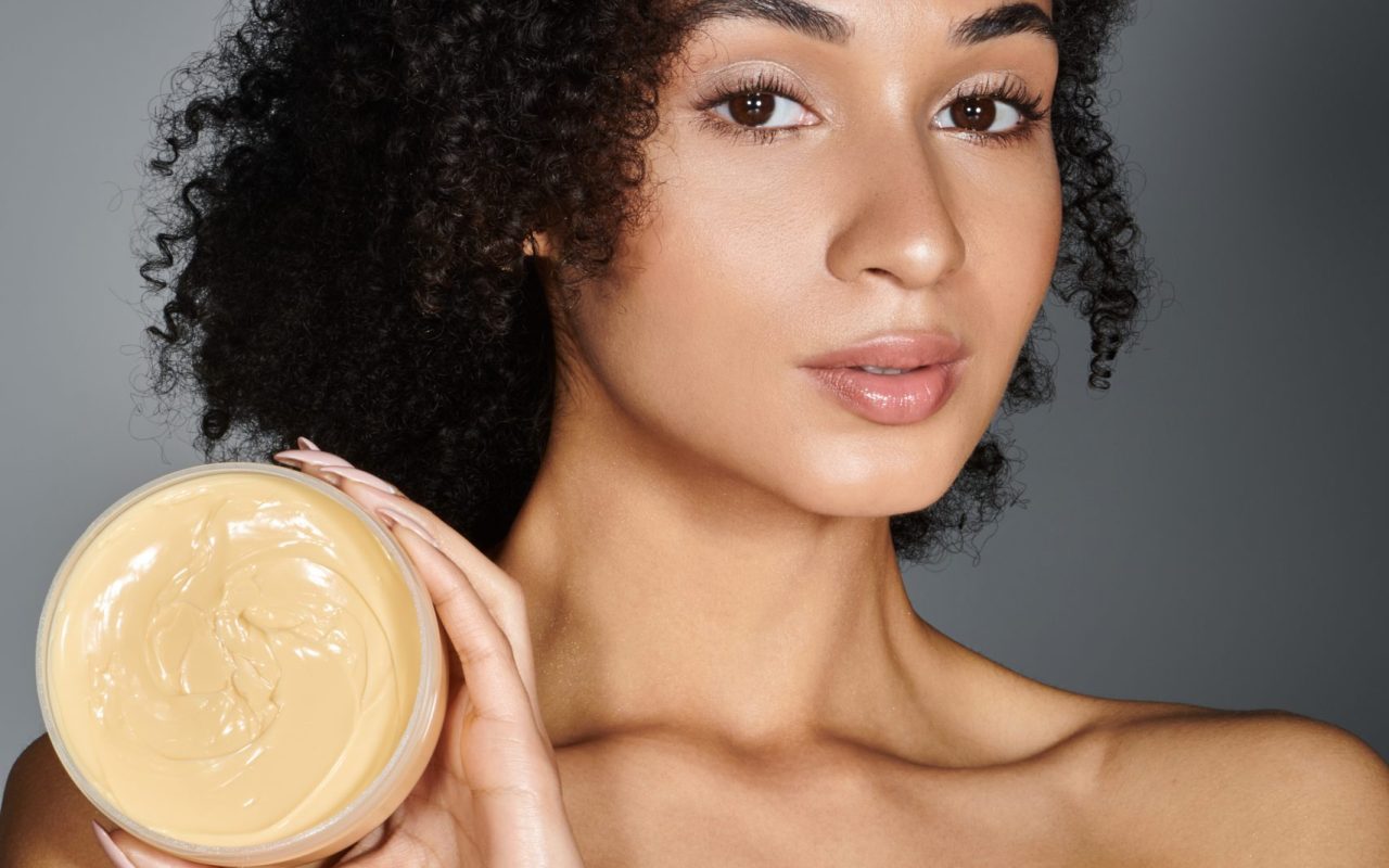 A stylish woman confidently presents her favorite skincare product, highlighting her beauty routine.